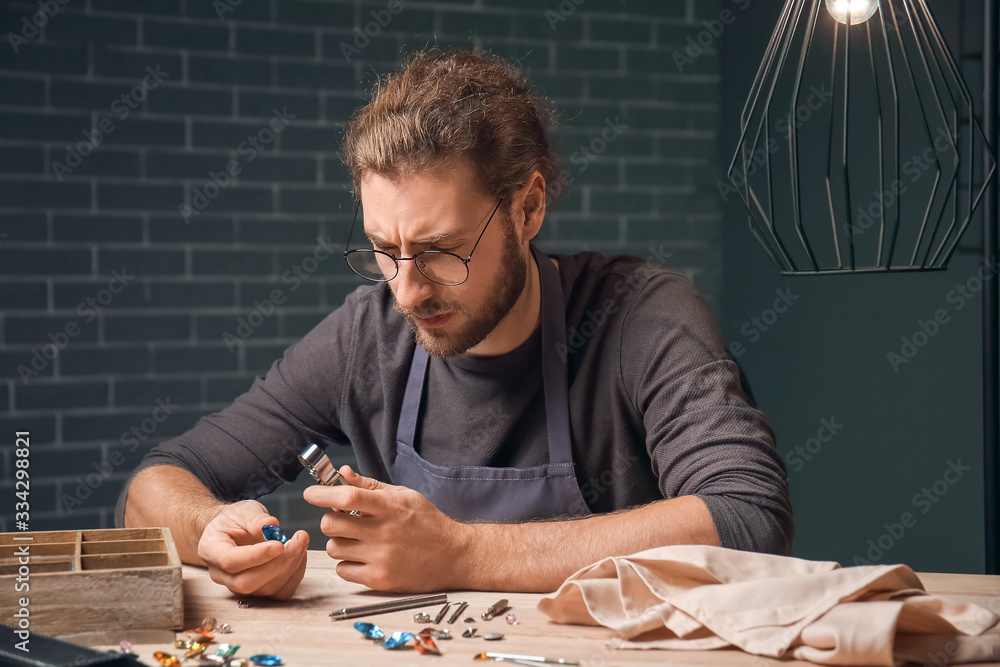 Jeweler examining gemstone in workshop