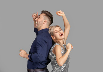 Wall Mural - Happy dancing young couple on grey background