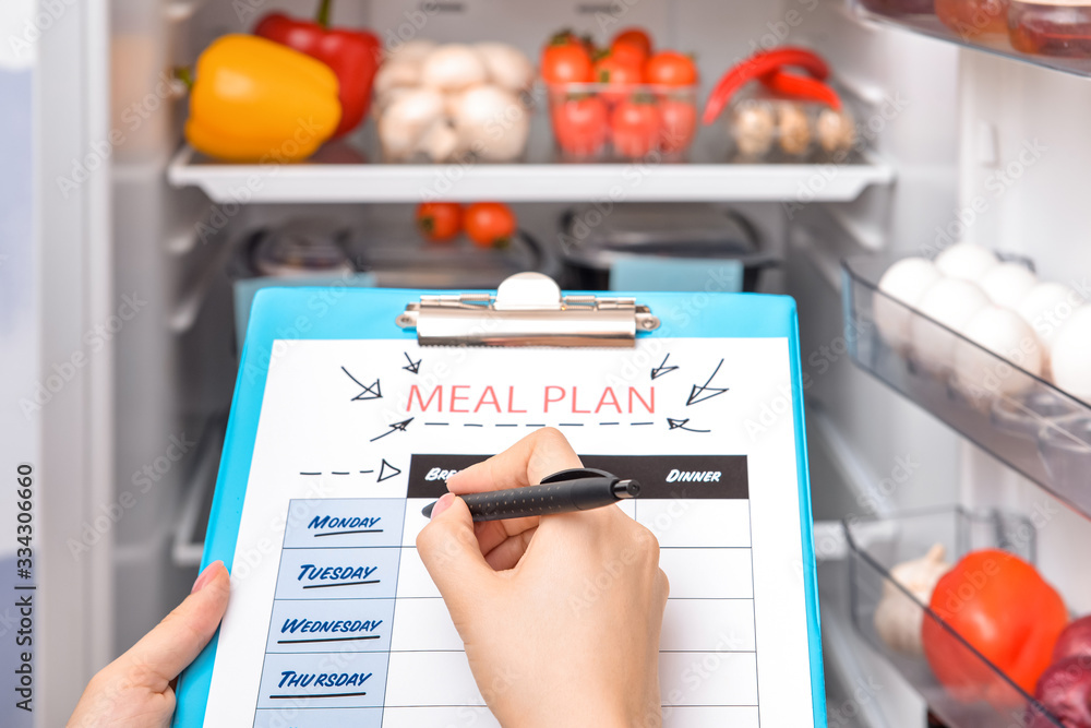 Woman making meal plan in kitchen