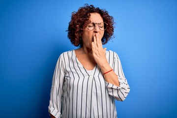 Poster - Middle age beautiful curly hair woman wearing casual striped shirt over isolated background bored yawning tired covering mouth with hand. Restless and sleepiness.