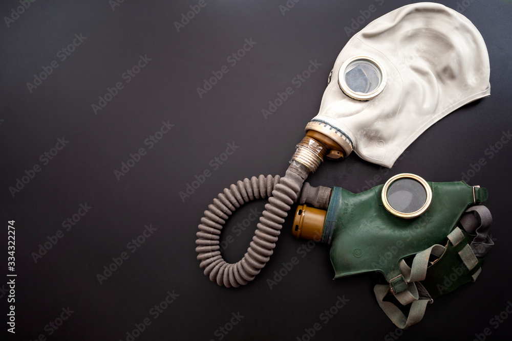 Codependent relationship, negative emotions, hazardous affair and toxic love concept with two gas masks connected on the same hose to represent codependency isolated on dark background with copy space - obrazy, fototapety, plakaty 