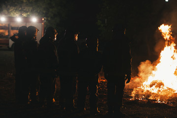 Wall Mural - Team of professional firefighters in front of a fire with firetruck in the background.