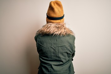 Canvas Print - Young brunette skier woman wearing snow clothes and ski goggles over white background standing backwards looking away with crossed arms