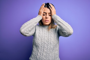 Poster - Young beautiful woman wearing casual sweater standing over isolated purple background suffering from headache desperate and stressed because pain and migraine. Hands on head.