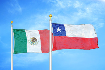 Mexico and Chile two flags on flagpoles and blue cloudy sky