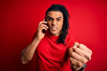 Wall Mural - Young african american afro man with dreadlocks having conversation talking on smartphone annoyed and frustrated shouting with anger, crazy and yelling with raised hand, anger concept