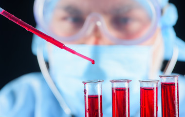 Blood test. Man in laboratory analyzing blood. Scientist. Doctor in laboratory with blood test. Laboratory technician working with test tubes in laboratory. Medical equipment. DNA.