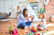 © Krakenimages.com - Caucasian girl kid playing and learning at playschool with female teacher. Mother and daughter at playroom around toys playing with bulding blocks