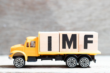 Wall Mural - Truck hold letter block in word IMF (abbreviation of International Monetary Fund) on wood background