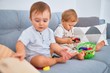© Krakenimages.com - Beautiful toddlers sitting on the sofa playing with toys at home