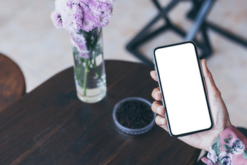 Mockup image blank white screen cell phone.woman hand holding texting using mobile on desk at coffee shop.background empty space for advertise text.people contact marketing business,technology