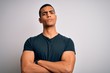 © Krakenimages.com - Young handsome african american man wearing casual t-shirt standing over white background skeptic and nervous, disapproving expression on face with crossed arms. Negative person.