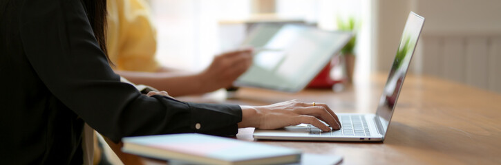 Side view of two college girl working on their assignment in comfortable workspace