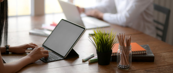 Side view of two young university students concentrating on their assignment on wooden desk