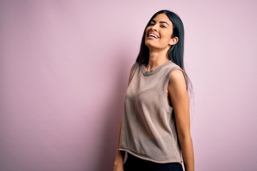 Young beautiful woman wearing fashion urban clothes, model wearing casual street style standing over pink background