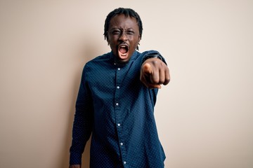 Canvas Print - Young handsome african american man wearing casual shirt standing over white background pointing displeased and frustrated to the camera, angry and furious with you