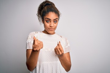 Young beautiful african american girl wearing casual t-shirt standing over white background doing money gesture with hands, asking for salary payment, millionaire business