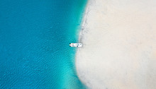 Aerial Seascape View Of Boat In Transparent Blue Water And White Beach In Summer Tropical Paradise Island Sand Bar. 