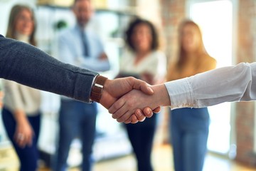 Group of business workers standing together shaking hands at the office