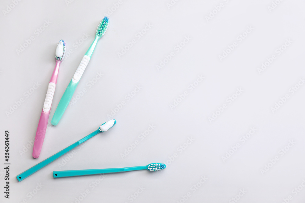 Tooth brushes with paste on light background