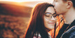 © Strelciuc - Charming caucasian couple kissing and embracing closely in a field with perfect sunset