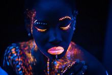Portrait Of Young African Woman With Colorful Abstract Make-up On Face. Unusual, Interesting, Fantastic Shoot. Body Art, Neon Lights, Fluorescence