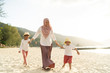 © Faiz - Asian kids having leisure time with their mother at the beach.