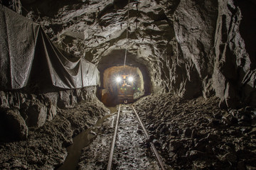 Electric locomotive in underground gold mine tunnel