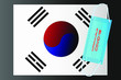 © Eugene B-sov - South Korea flag with vector illustration of disposable mask and Covid-19 inscription