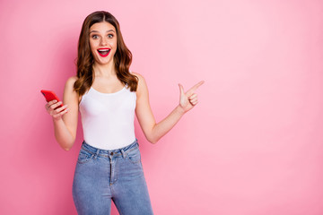 Sticker - Crazy excited girl addicted social media promoter use smartphone point finger copyspace present incredible ads promotion wear white singlet tank-top jeans denim isolated pink color background