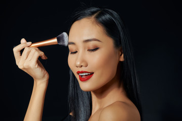 Wall Mural - Young asian woman doing make-up