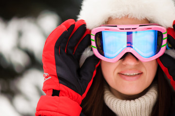 young girl in a red sports jacket in the winter forest skiing,