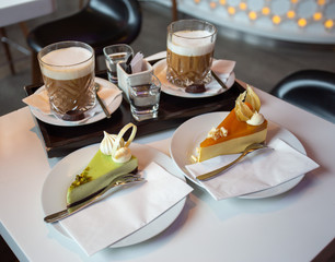 Side view of two cakes and coffee on a table