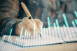 © peshkova - Double exposure of woman's hands making notes with forex graph hologram. Concept technical analysis.