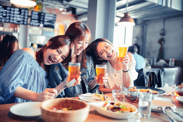 Wall Mural - happy young woman sitting in  restaurant and enjoy dinner and beer