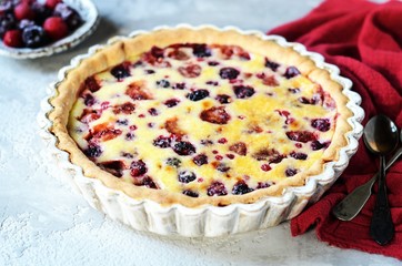 Wall Mural - Tart with berries in sour cream filling on a gray background