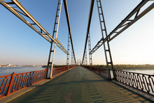 Pedestrian Iron Bridge Across The Dnepr In Kiev, Ukraine..Perspective At The Bridge. Bridge With Geometrical Metal Structure. Pedestrian Overpass. Abstract View Of A Large Suspension Bridge.