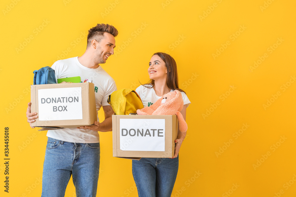Volunteers with donations for orphans on color background