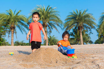 Brother and sister two children funny digging play toy with sand