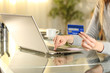 © PheelingsMedia - Shopper hands paying with credit card on laptop at home