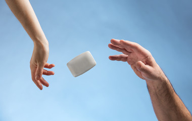 Male and female hands and soap. Blue background. Levitation.