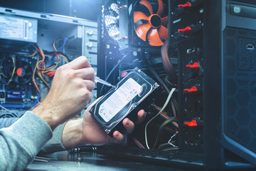 Technician repairing a computer, the process of replacing components on the motherboard. The technician hold the screwdriver for repairing PC. The concept of computer hardware, repairing, upgrade