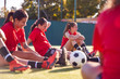 © Monkey Business - Womens Football Team Stretching Whilst Training For Soccer Match On Outdoor Astro Turf Pitch