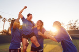Womens Football Team Celebrating Winning Soccer Match Lifting Player Onto Shoulders