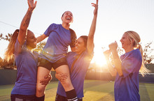Womens Football Team Celebrating Winning Soccer Match Lifting Player Onto Shoulders