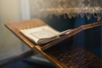 Quran islamic holy book on dark background with with blurred traditional carpet for reading in ramadan night