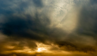 Wall Mural - a wide panoramic view of the dramatic sky with thick clouds and an orange glow from sunlight. vibrant artistic backdrop for creative mockup