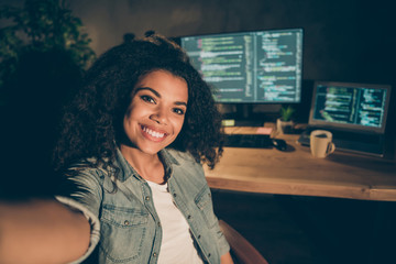 Positive joyful afro american girl web designer sit late evening office make self portrait show her java script data administrator work table desk computer in workstation workplace
