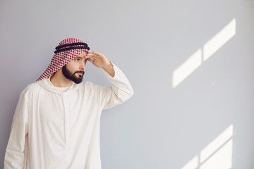 Wall Mural - Attractive smiling arab man looking on a gray background