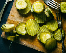 Sliced Artisan Pickles On A Wooden Cutting Board. Homemade Pickle Chips. 